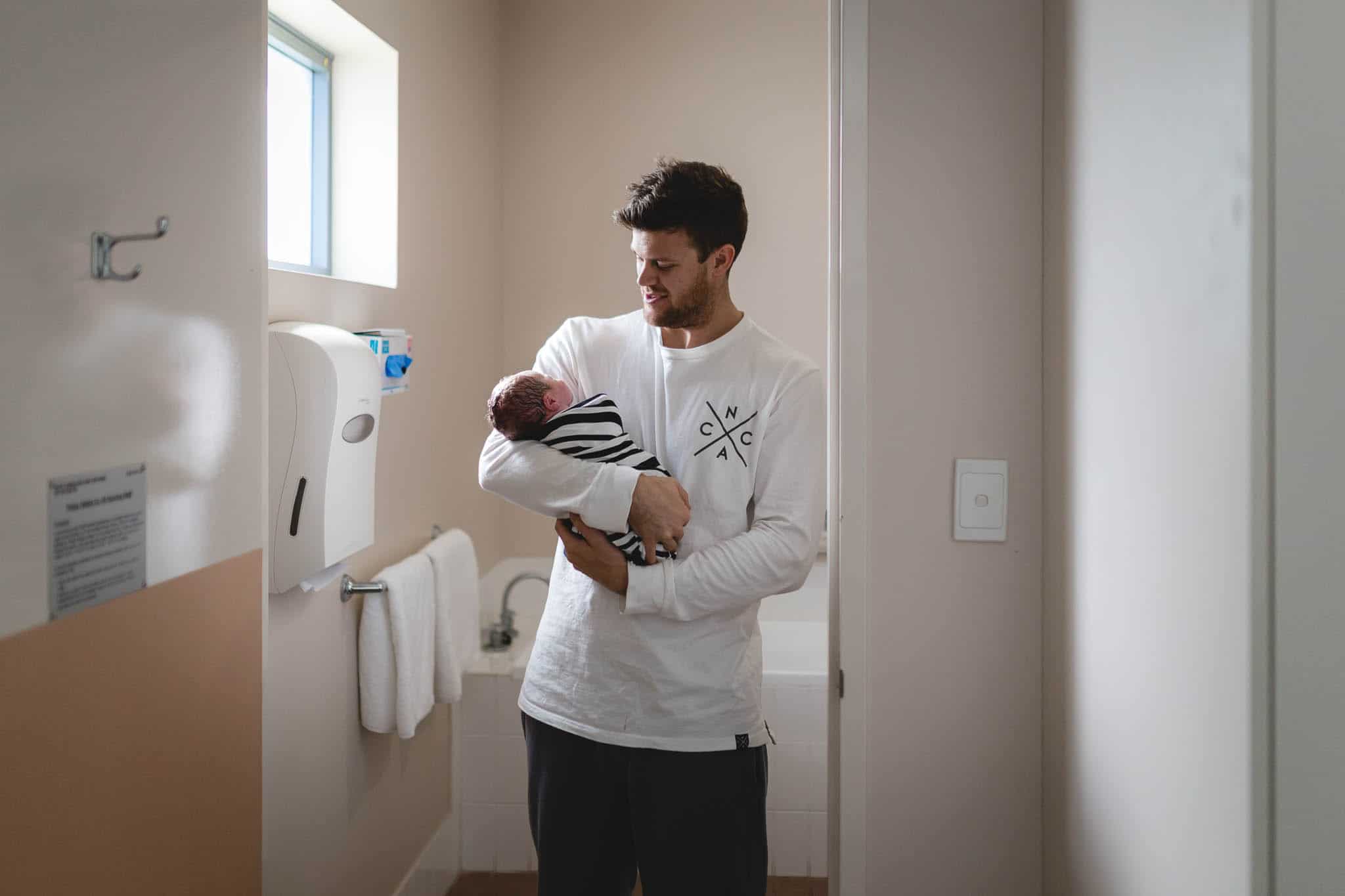 Newcastle Birth Photographer | Newborn Sonny being held by his dad