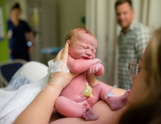 Newborn baby being held after birth
