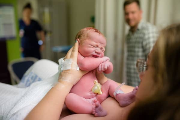 Newborn baby being held after birth